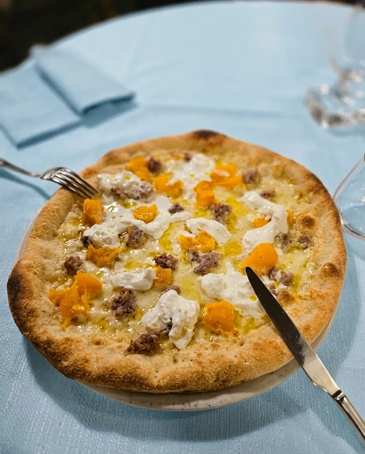 Pizza con zucca, salsiccia e stracciatella (immagine generata con AI)